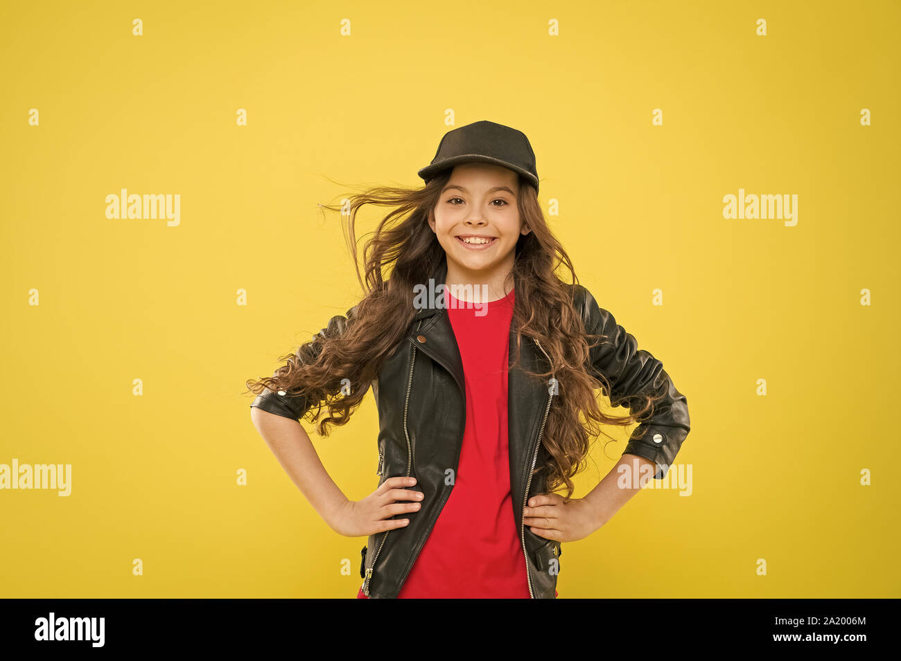 Comfortable style. Adorable stylish girl smiling on yellow