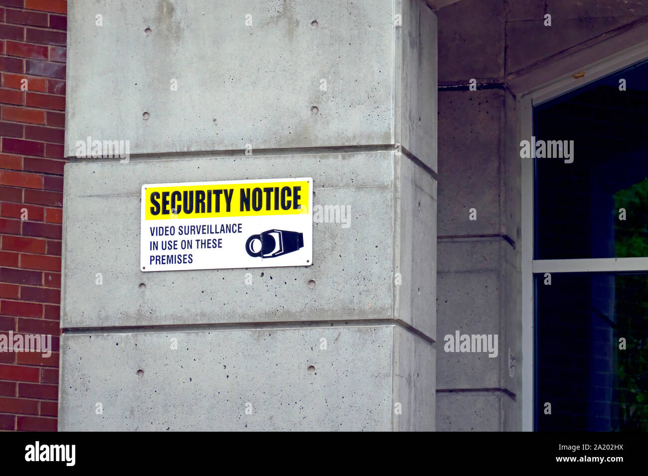 Security Notice 'Video Surveillance in Use on These Premises' on cement pillar. Stock Photo