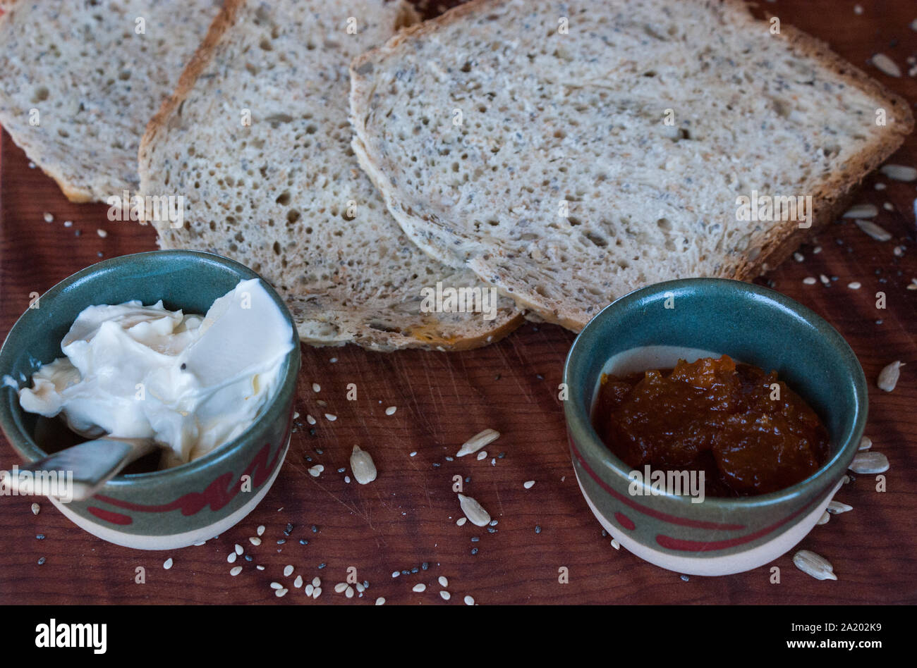 A healthy breakfast with homemade bread, spreadable cheese and pumpkin jam. Stock Photo