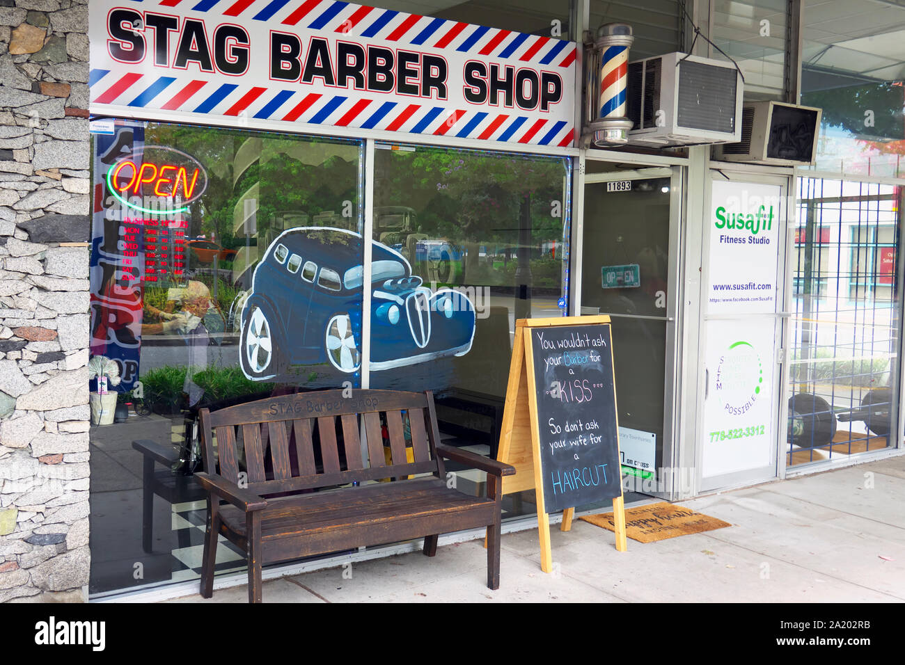 Stag Barber Shop shop window with a chalk board and bench on the sidewalk.  Maple Ridge, British Columbia, Canada. Stock Photo