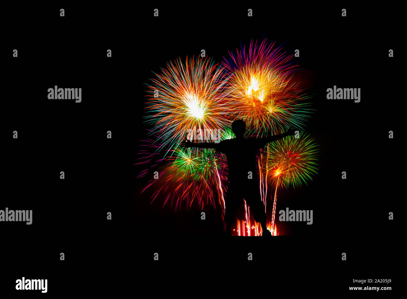 Silhouette successful man at the peak, Beautiful colorful fireworks display on the sea beach. Stock Photo