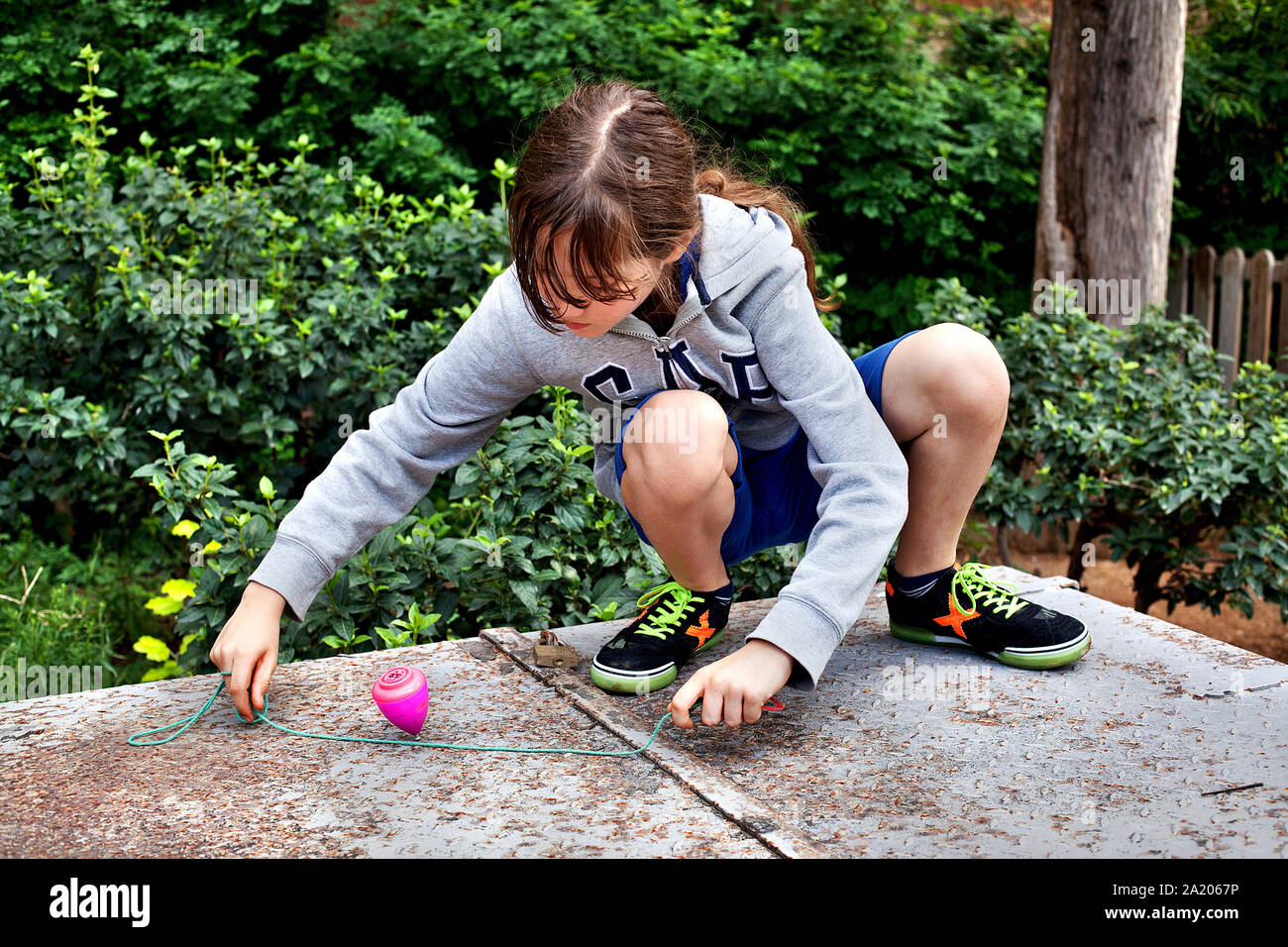 Ten year-old boy playing with spinning top Stock Photo - Alamy