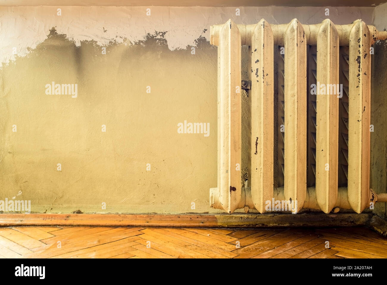 old cast iron radiators with peeling paint on the wall Stock Photo Alamy
