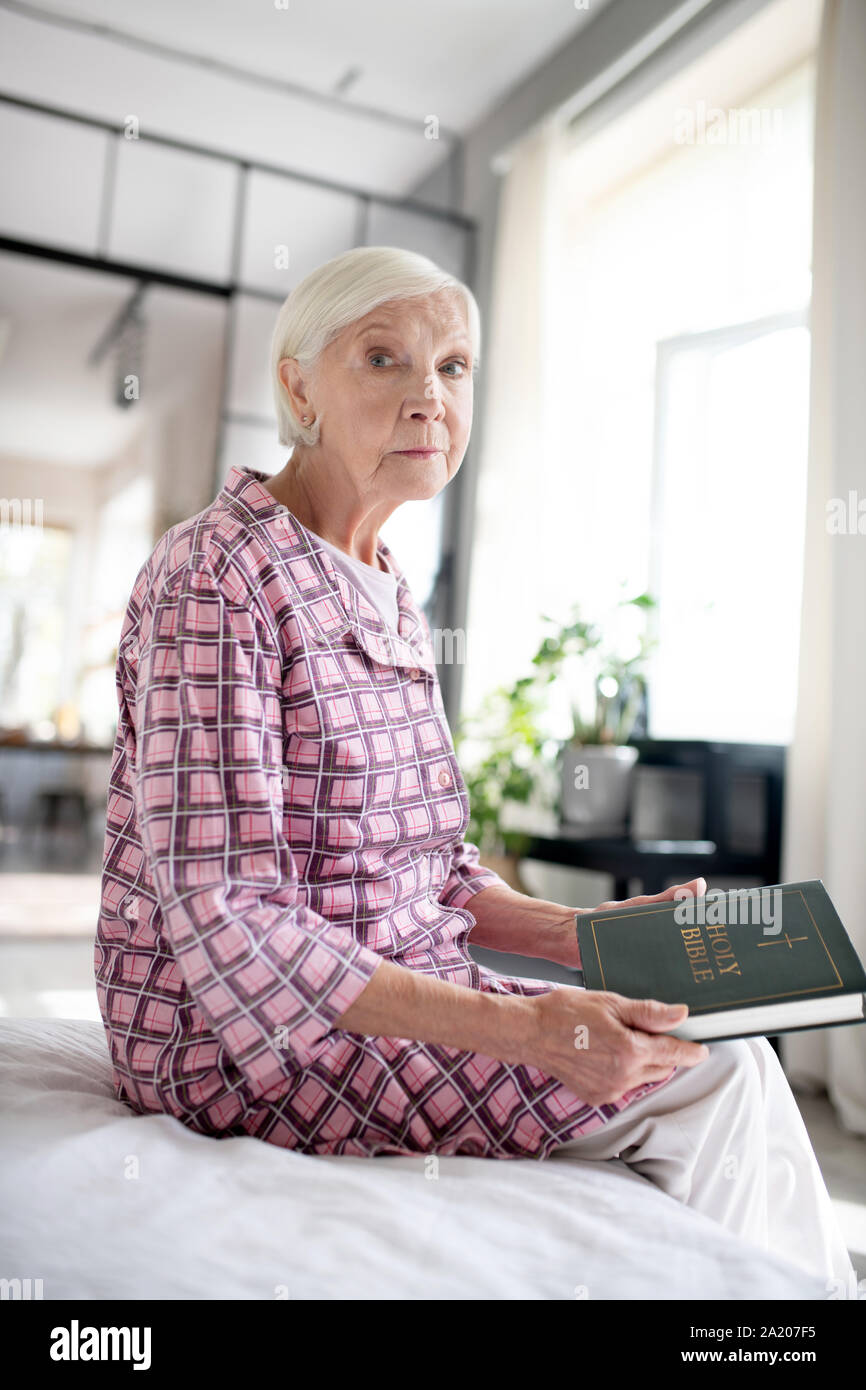 Aged Lady Holding Bible While Sitting On Sofa Stock Photo - Alamy