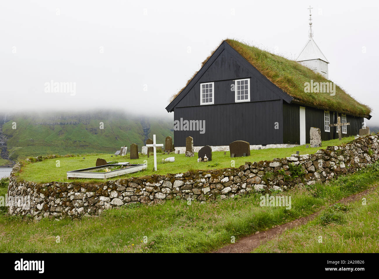 Traditional turf church in Faroe islands on foggy day. Kaldbak Stock Photo