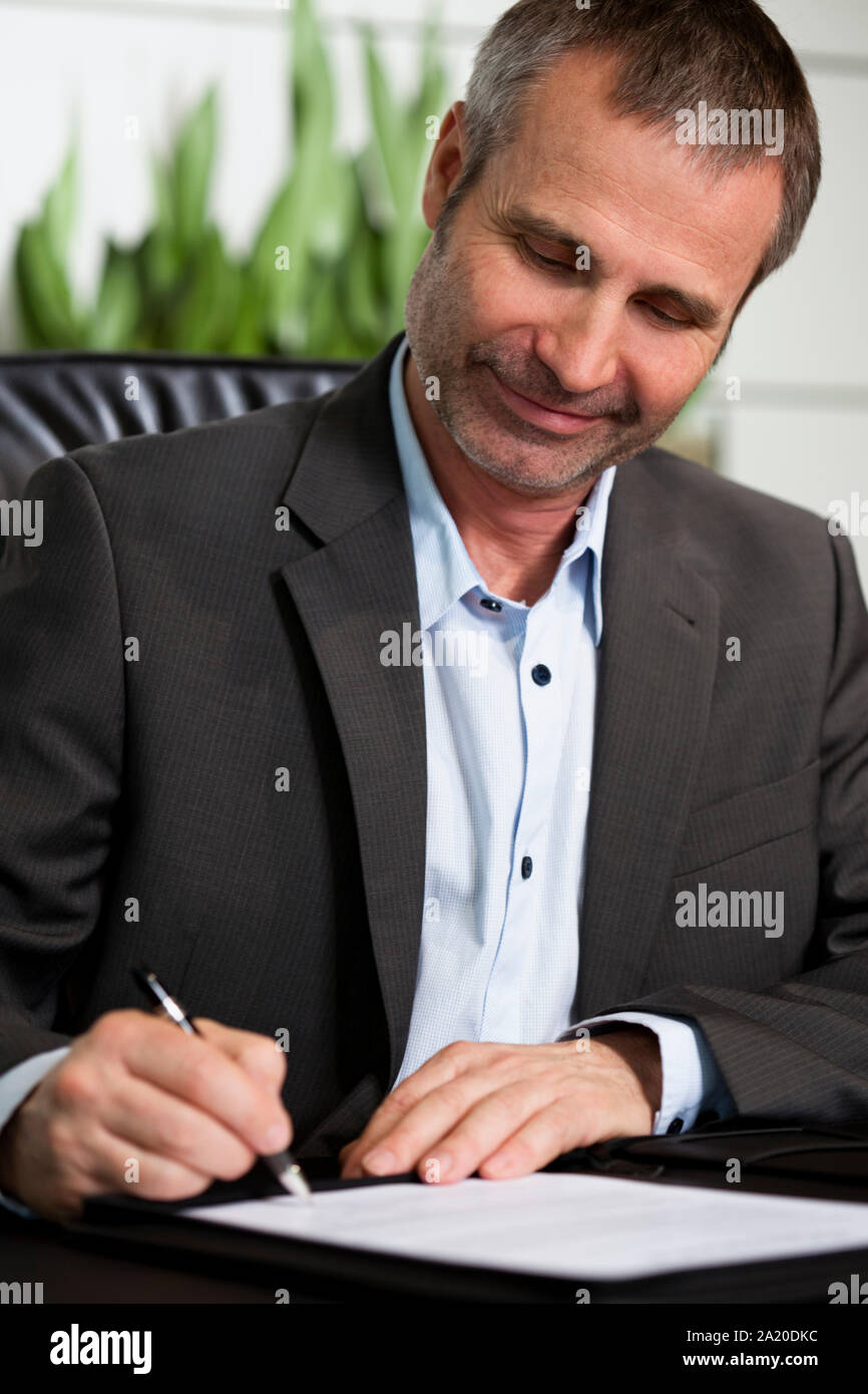 Happy business person signing a contract. Stock Photo