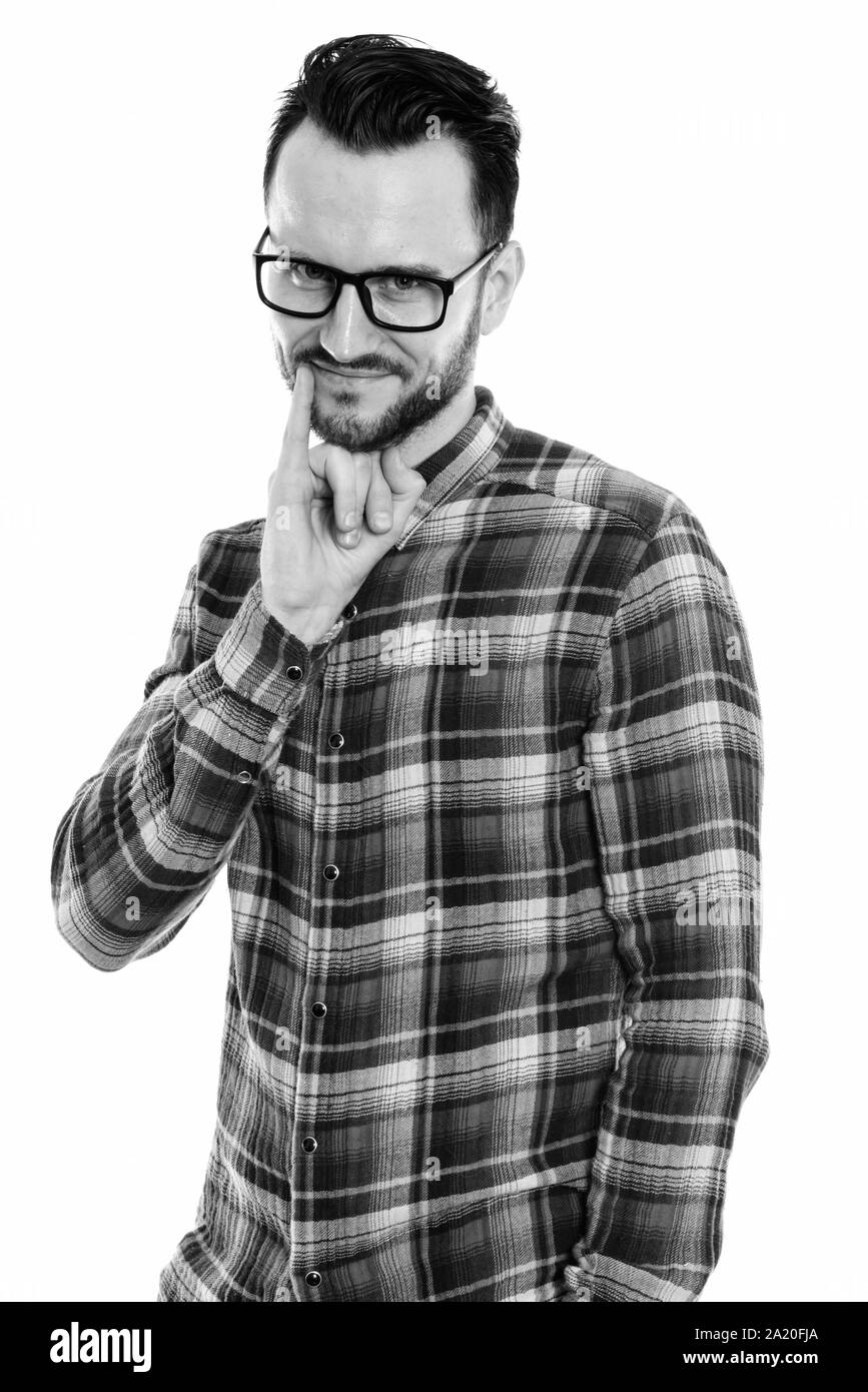 Studio shot of young man with pinky finger on mouth Stock Photo