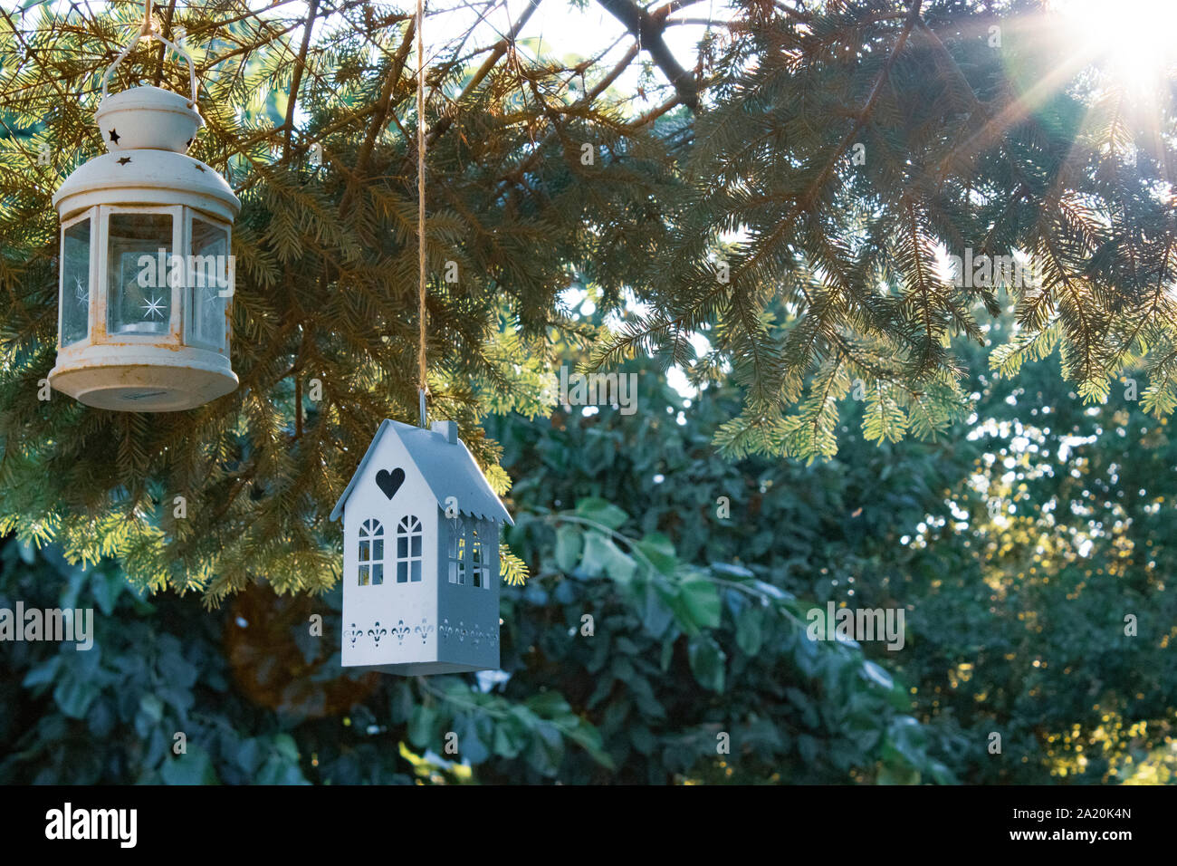 Toy house and lamp on pine tree. garden, nature background Stock Photo