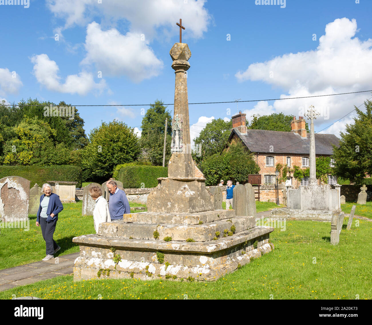 People walking to church past medieval preaching cross, Great Bedwyn ...