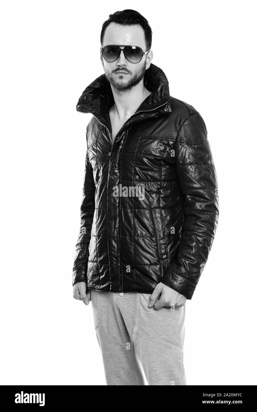 Studio shot of cool young man standing while wearing leather jacket Stock Photo