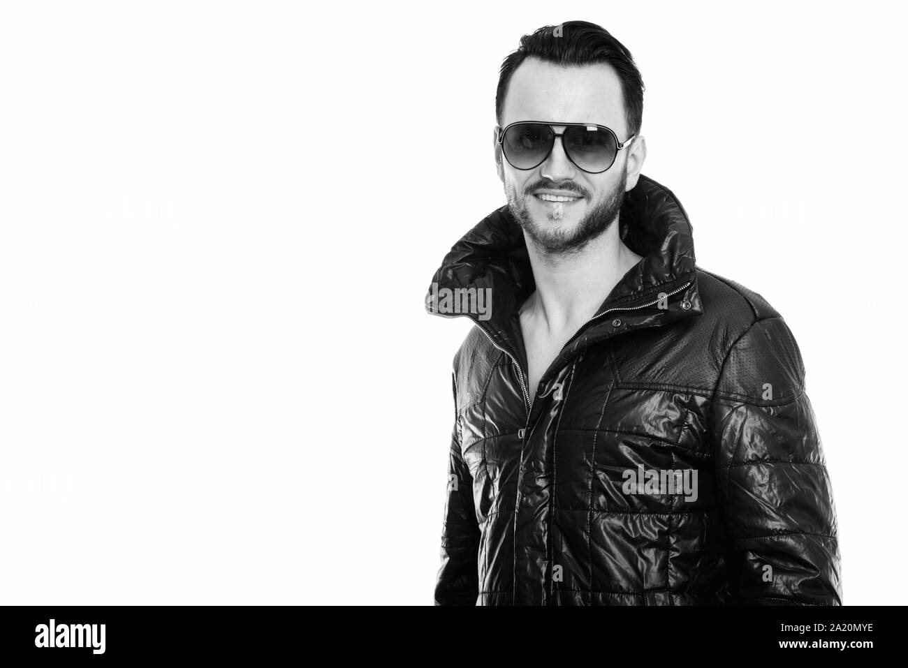 Studio shot of happy cool young man smiling while wearing sunglasses Stock Photo