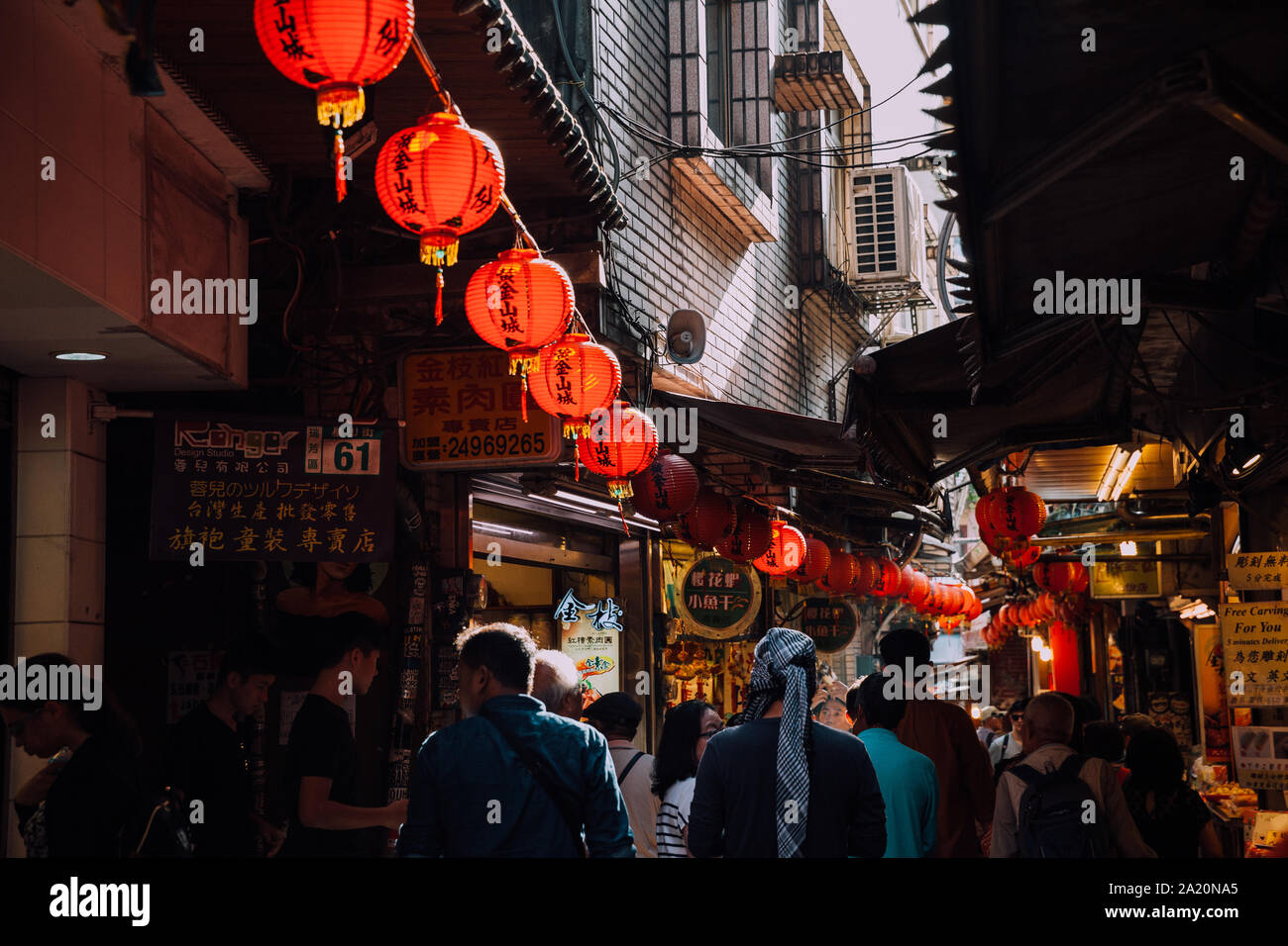 Jiufen, Taiwan - November 07, 2018: People walk with purchases along the crowded Old Street market on November 7, 2018, in Jiufen, Taiwan Stock Photo