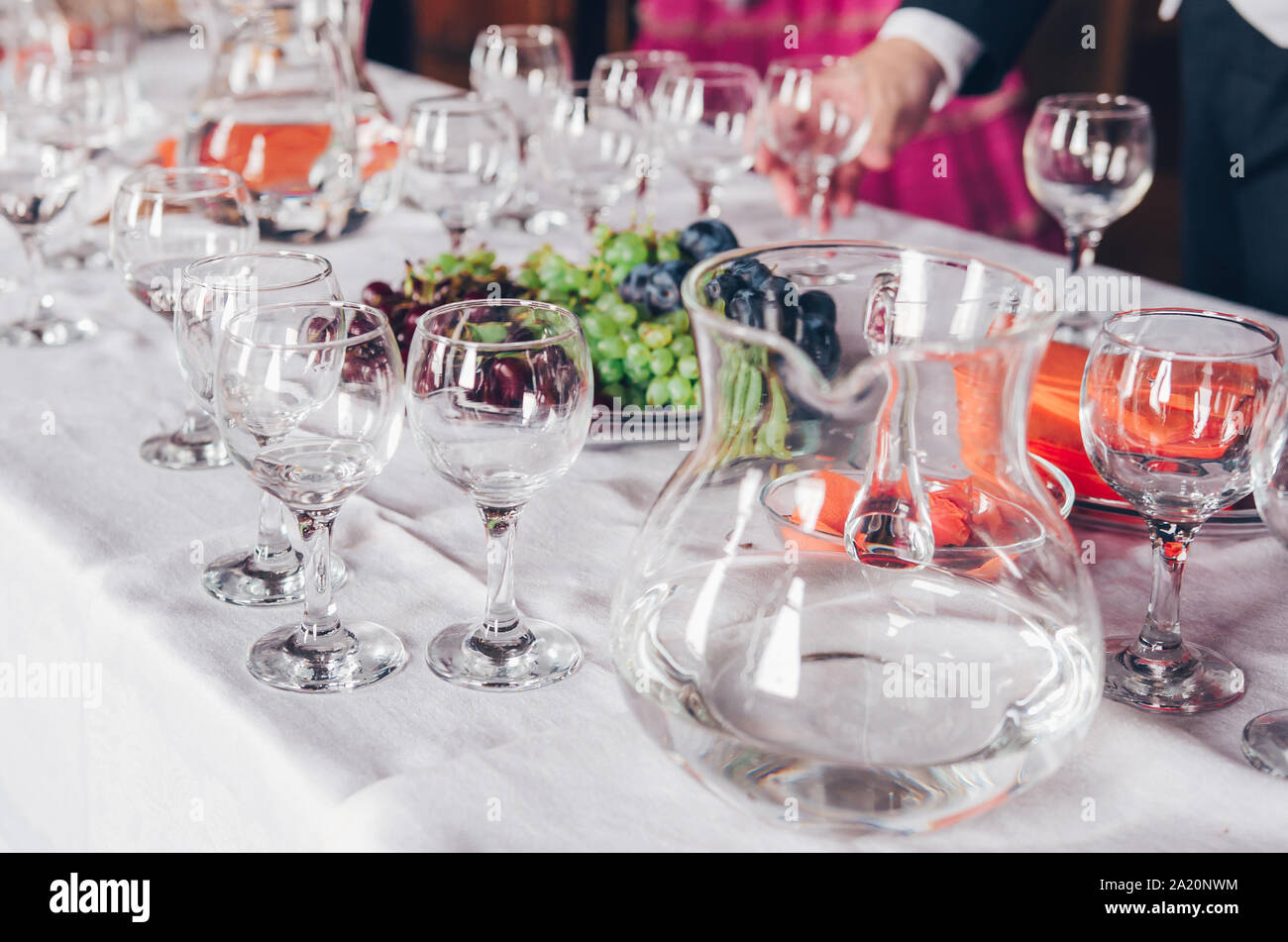 Serving food and drinks at event. Buffet table with water and grapes