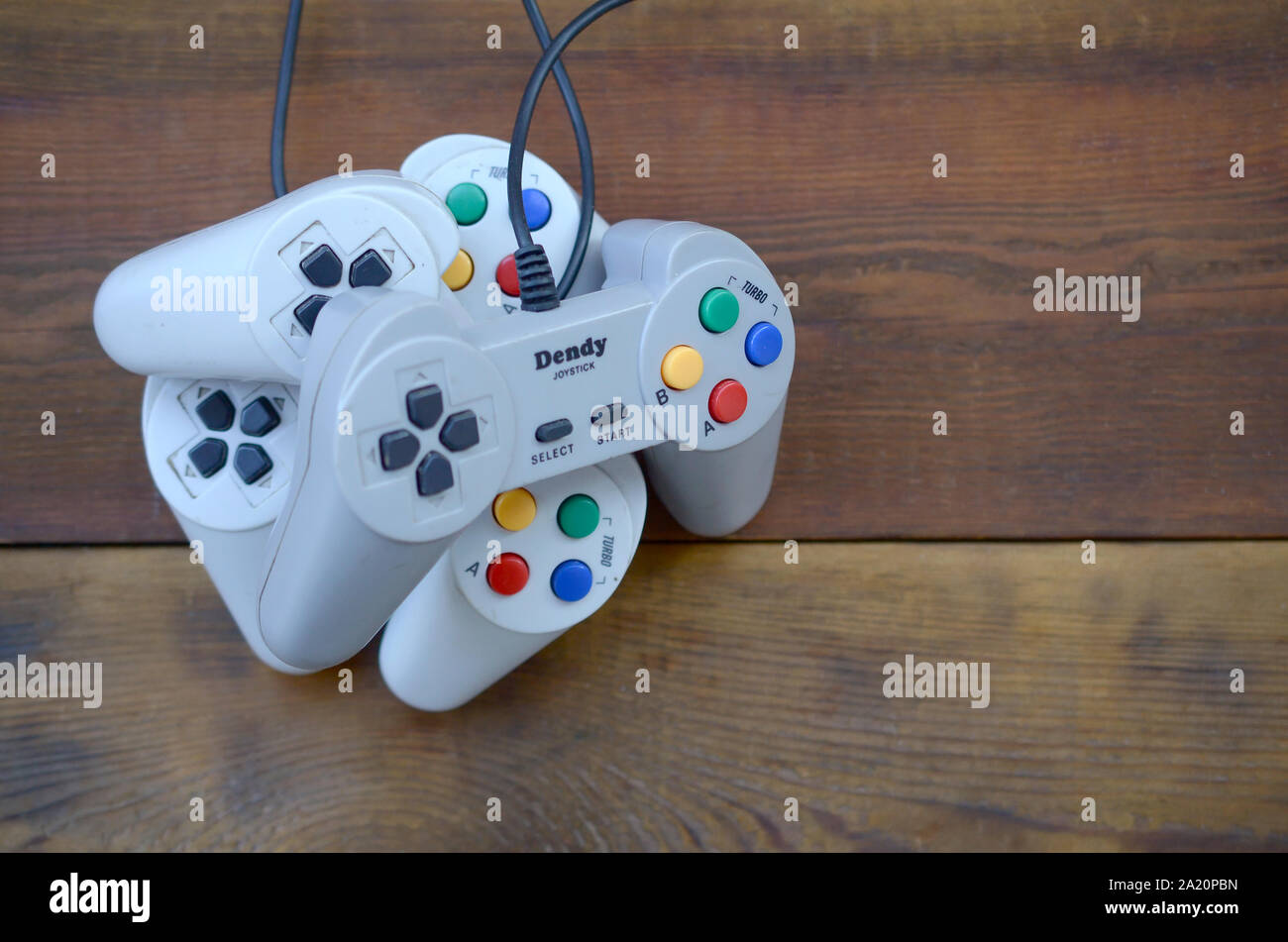 KHARKOV, UKRAINE - SEPTEMBER 18, 2019: Dendy video game console classic controllers on a wooden table. One of the most classic gaming consoles Stock Photo