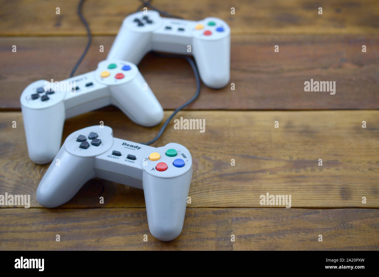 KHARKOV, UKRAINE - SEPTEMBER 18, 2019: Dendy video game console classic controllers on a wooden table. One of the most classic gaming consoles Stock Photo