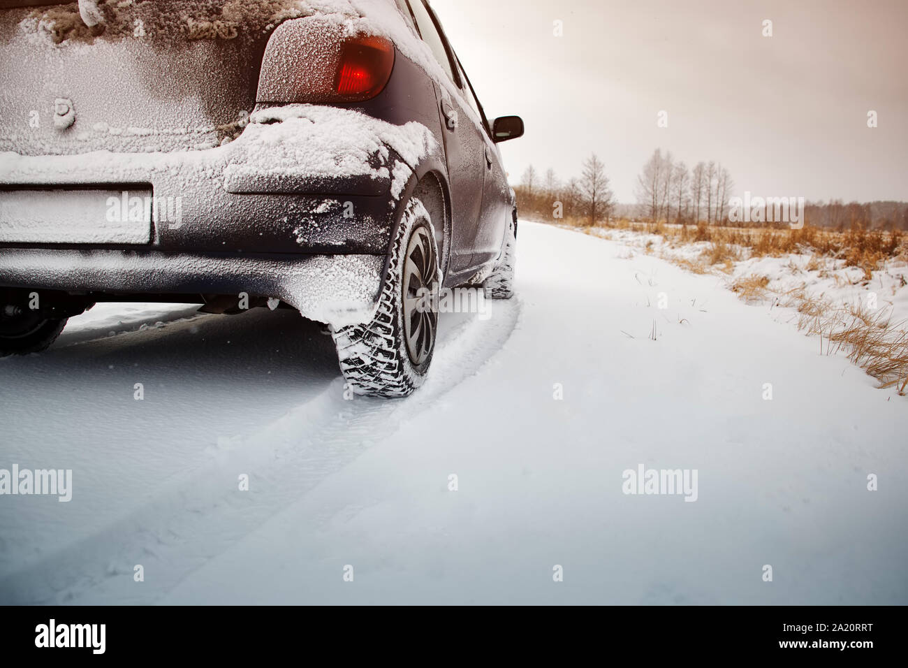 Car tires on winter road covered with snow Stock Photo - Alamy