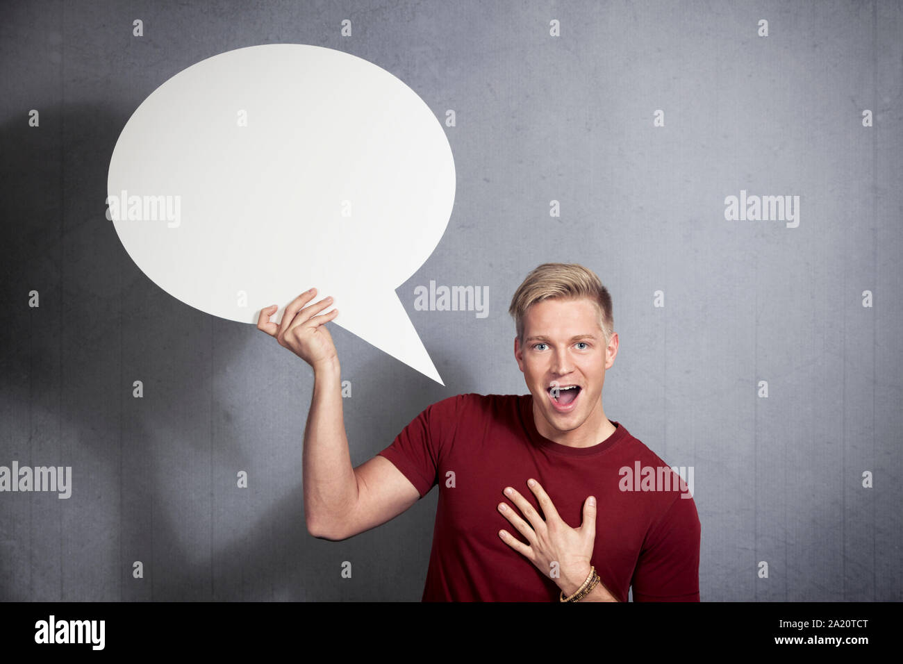 Joyful man holding empty speech bubble. Stock Photo