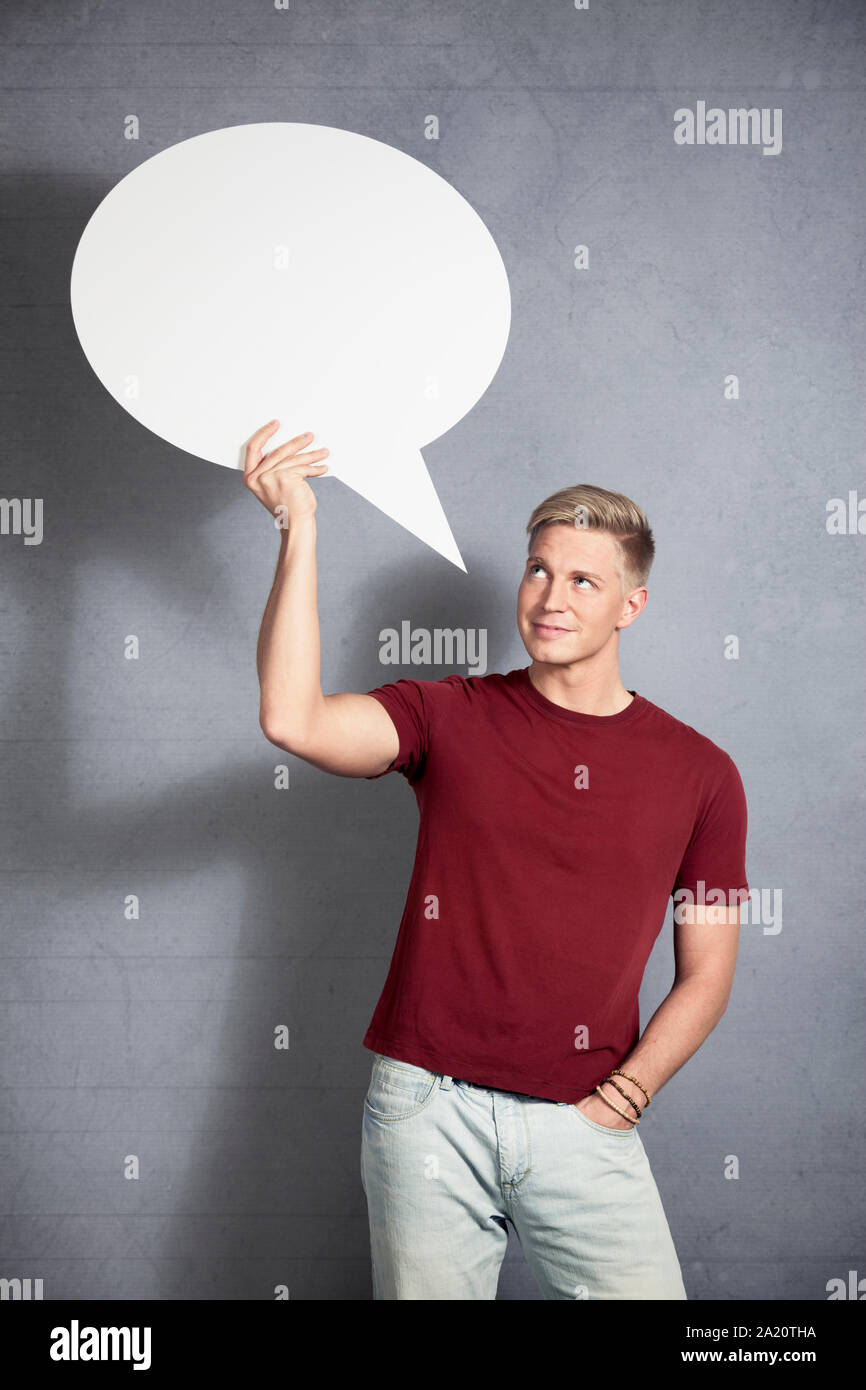 Smiling man looking at empty speech bubble. Stock Photo