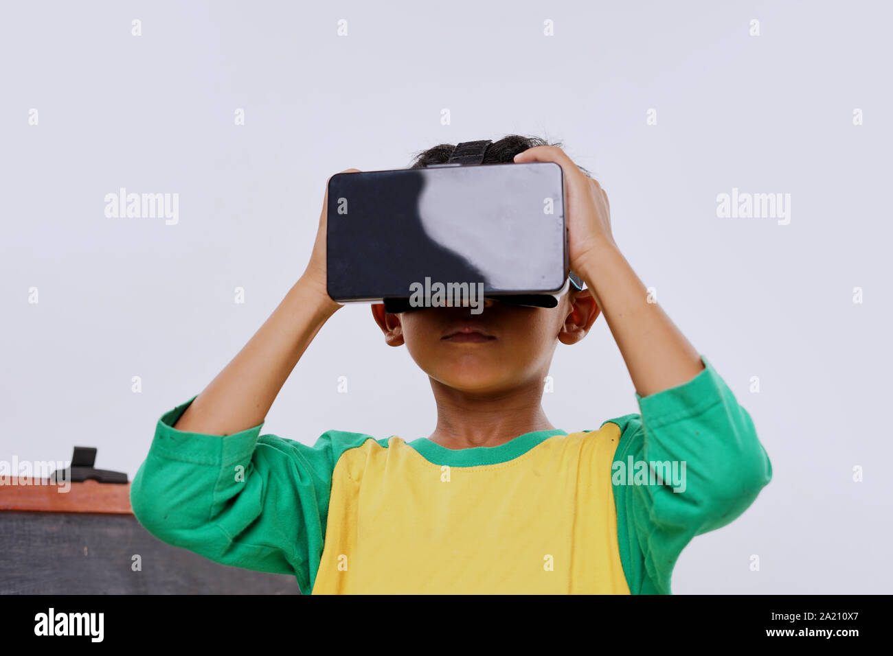 Schoolboy standing using virtual reality glasses on white background Stock Photo