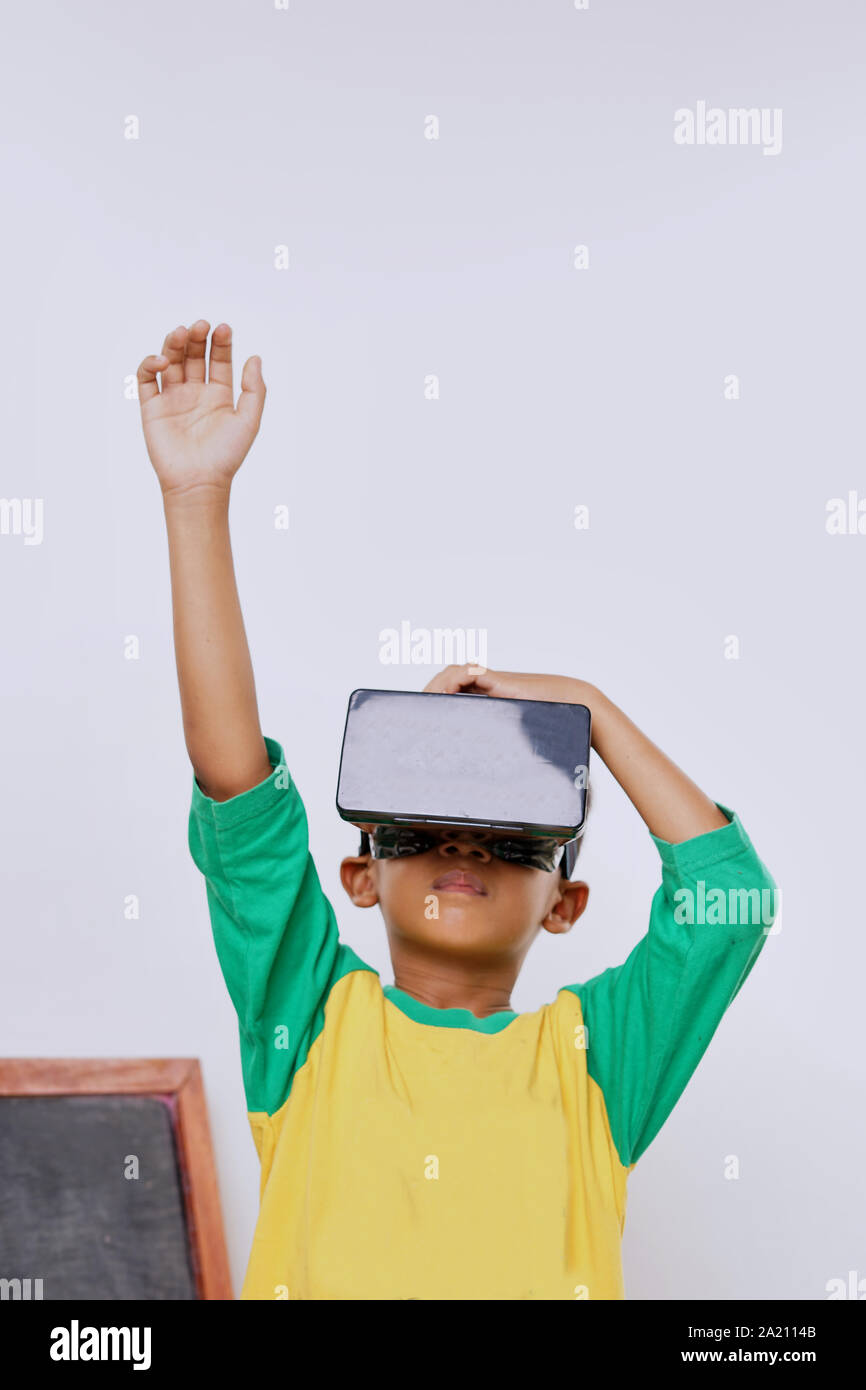 Schoolboy standing using virtual reality glasses on white background Stock Photo