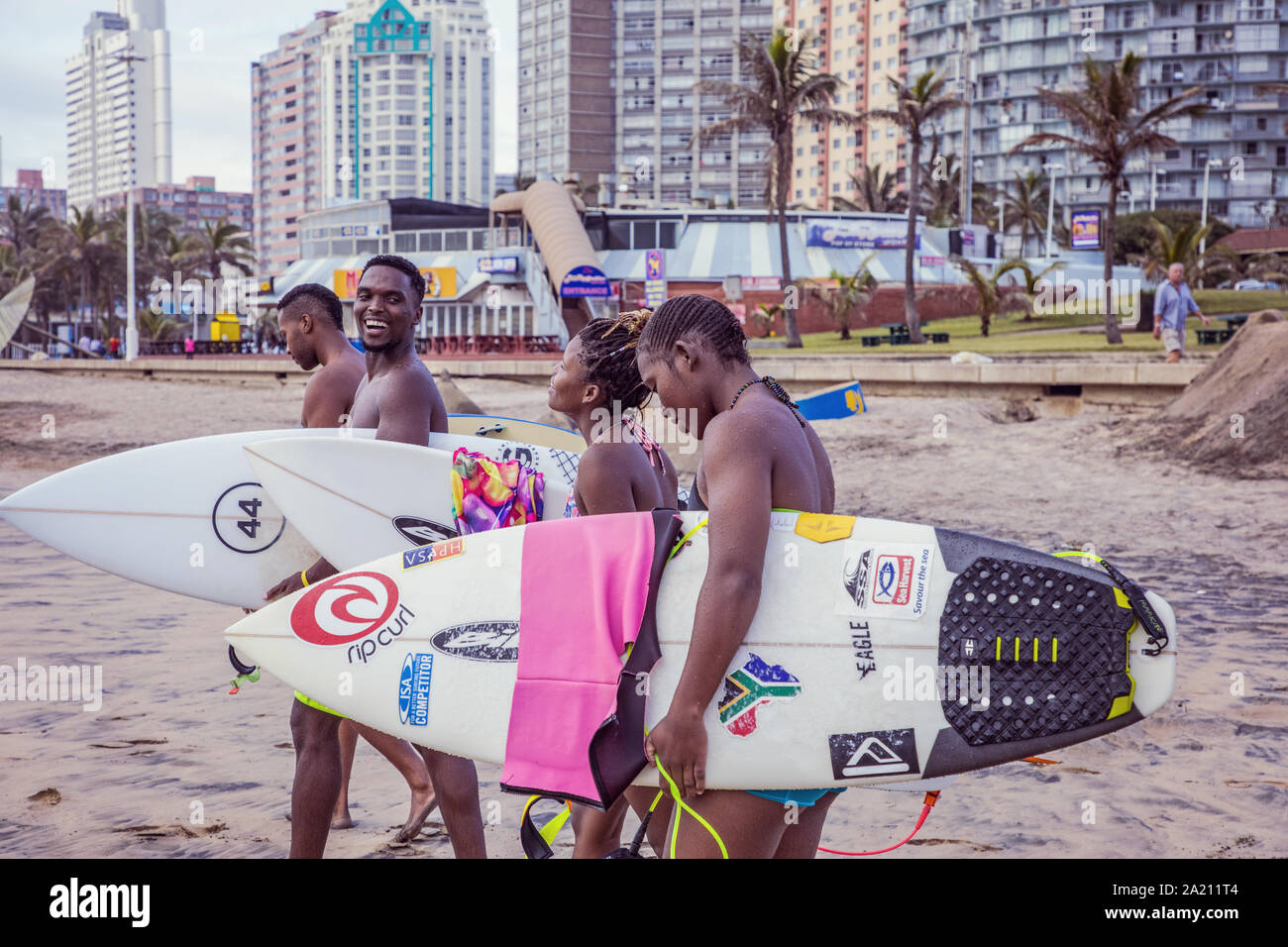 People walking with surfboards along Durban beach Stock Photo Alamy