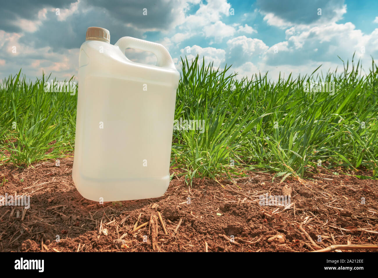 Blank pesticide jug container mock up in wheatgrass field. Using