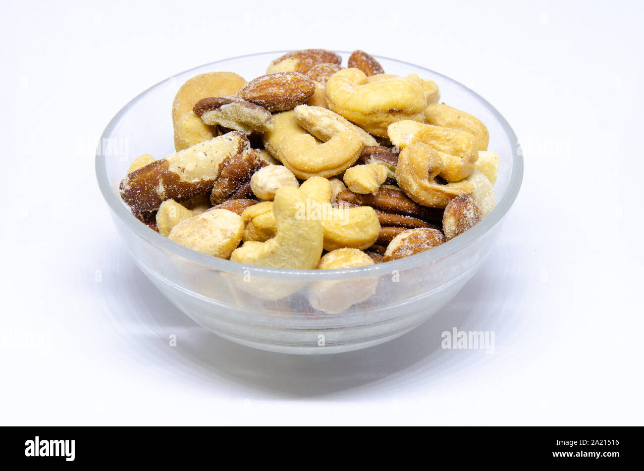 A small glass bowl of roasted and salted mixed nuts. Stock Photo
