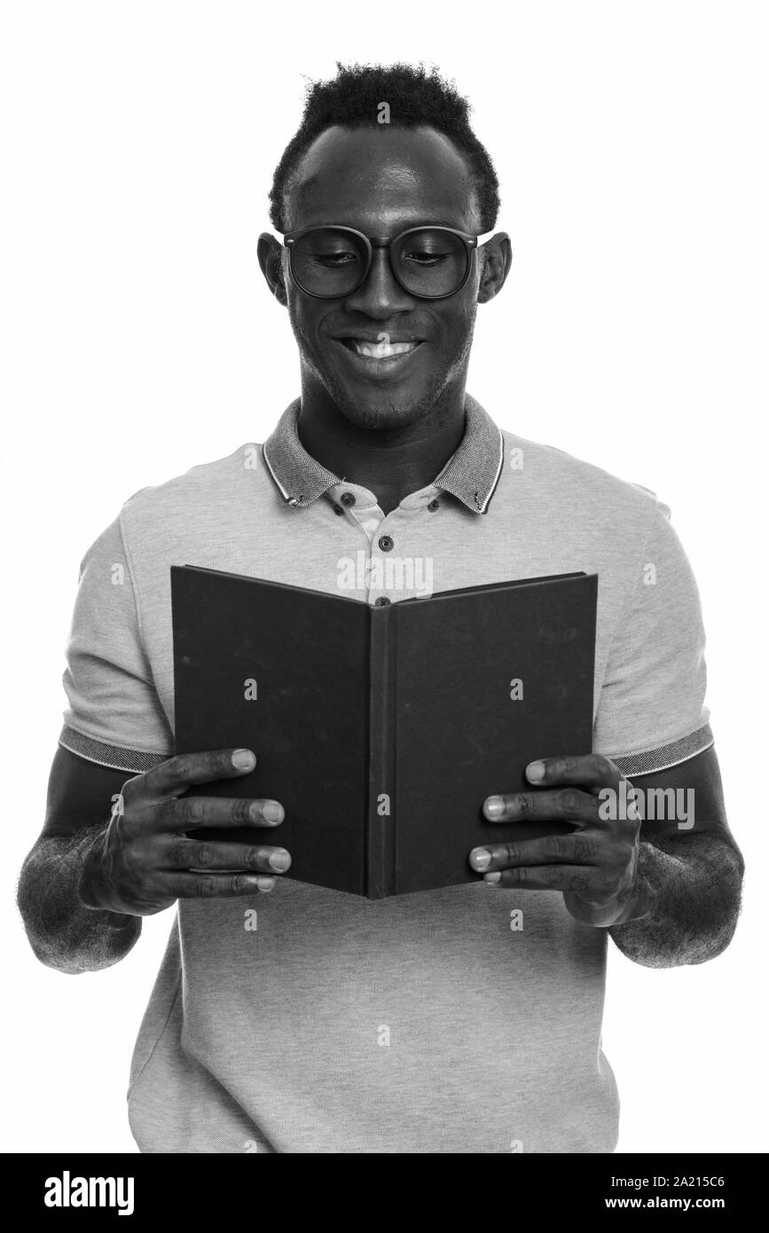 Young happy African man smiling while reading book Stock Photo - Alamy