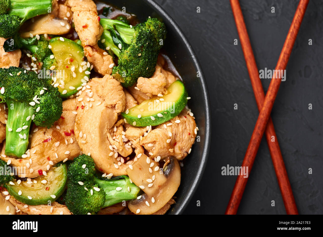 Hunan Chicken in black bowl at dark slate background. Hunan Chicken is