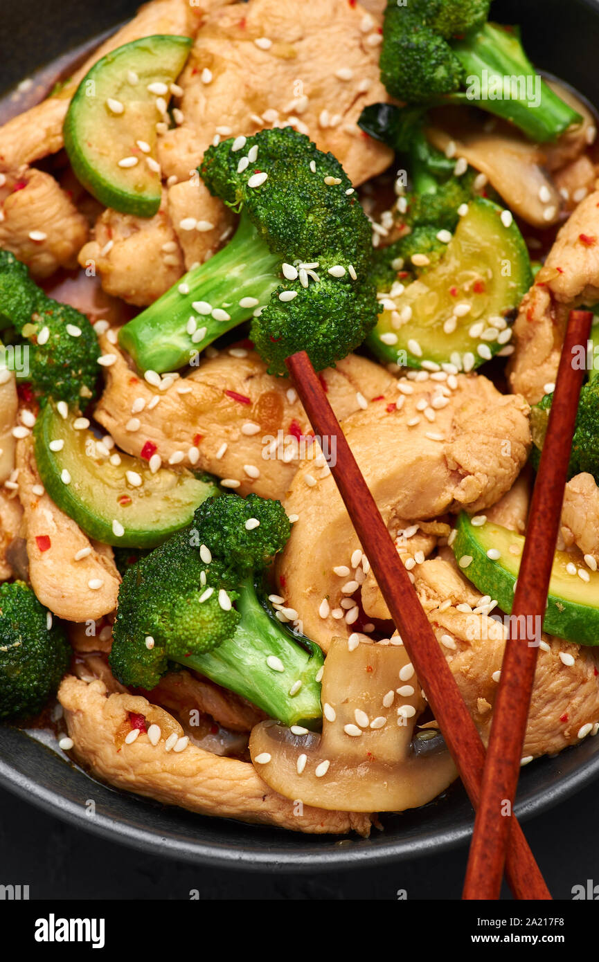 Hunan Chicken in black bowl at dark slate background. Hunan Chicken is