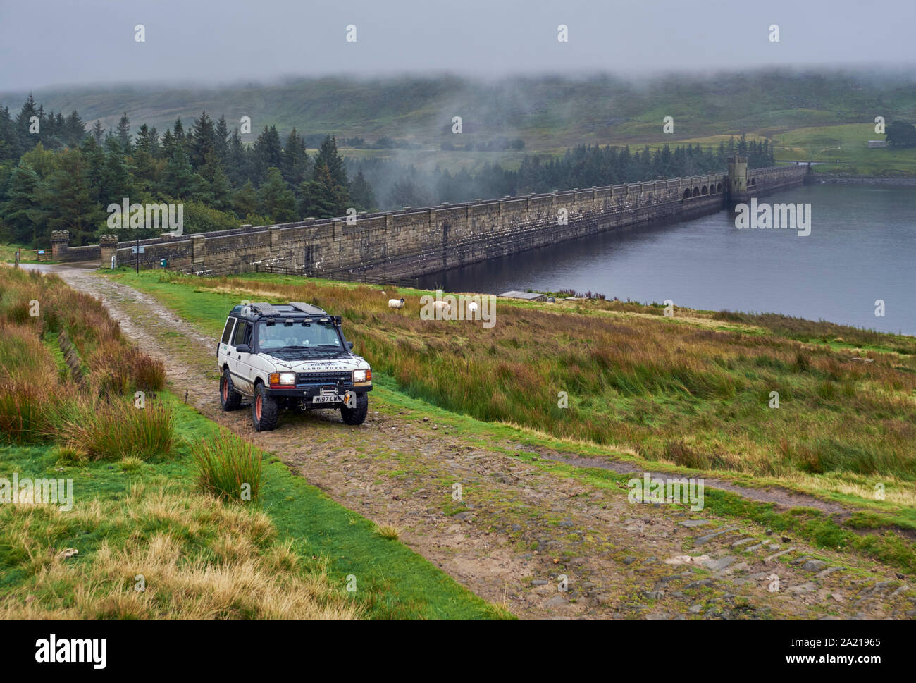 Car on unsurfaced road by Scar House Reservoir Dam. Yorkshire Dales