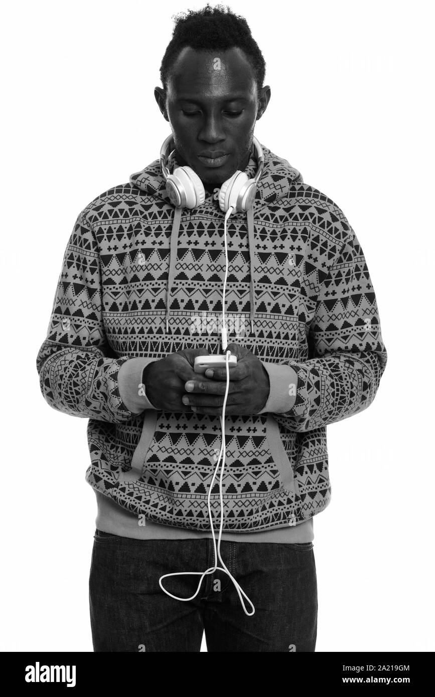 Young black African man using mobile phone while wearing headphones