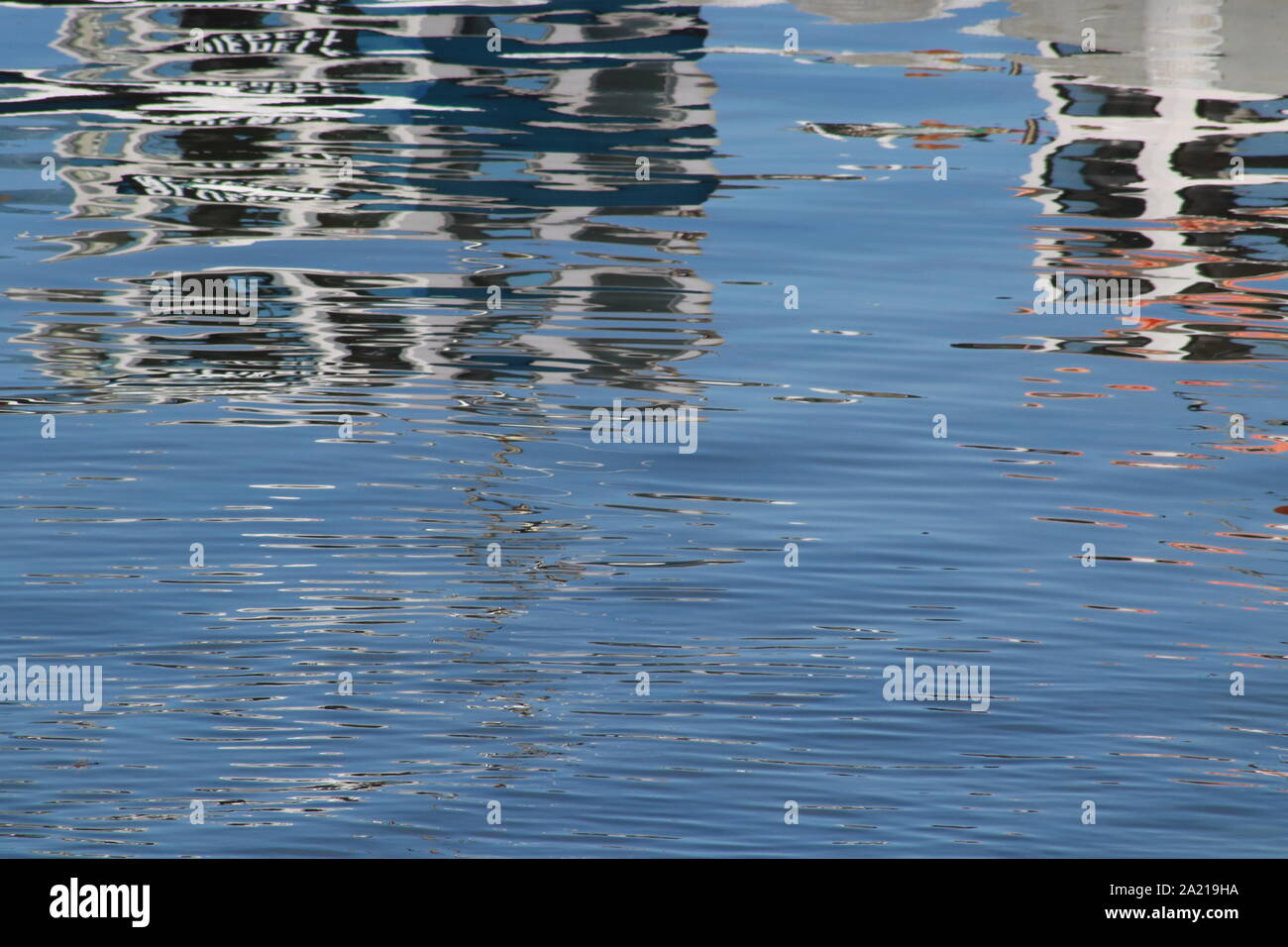 Fishing boats reflected in water of harbour Stock Photo - Alamy