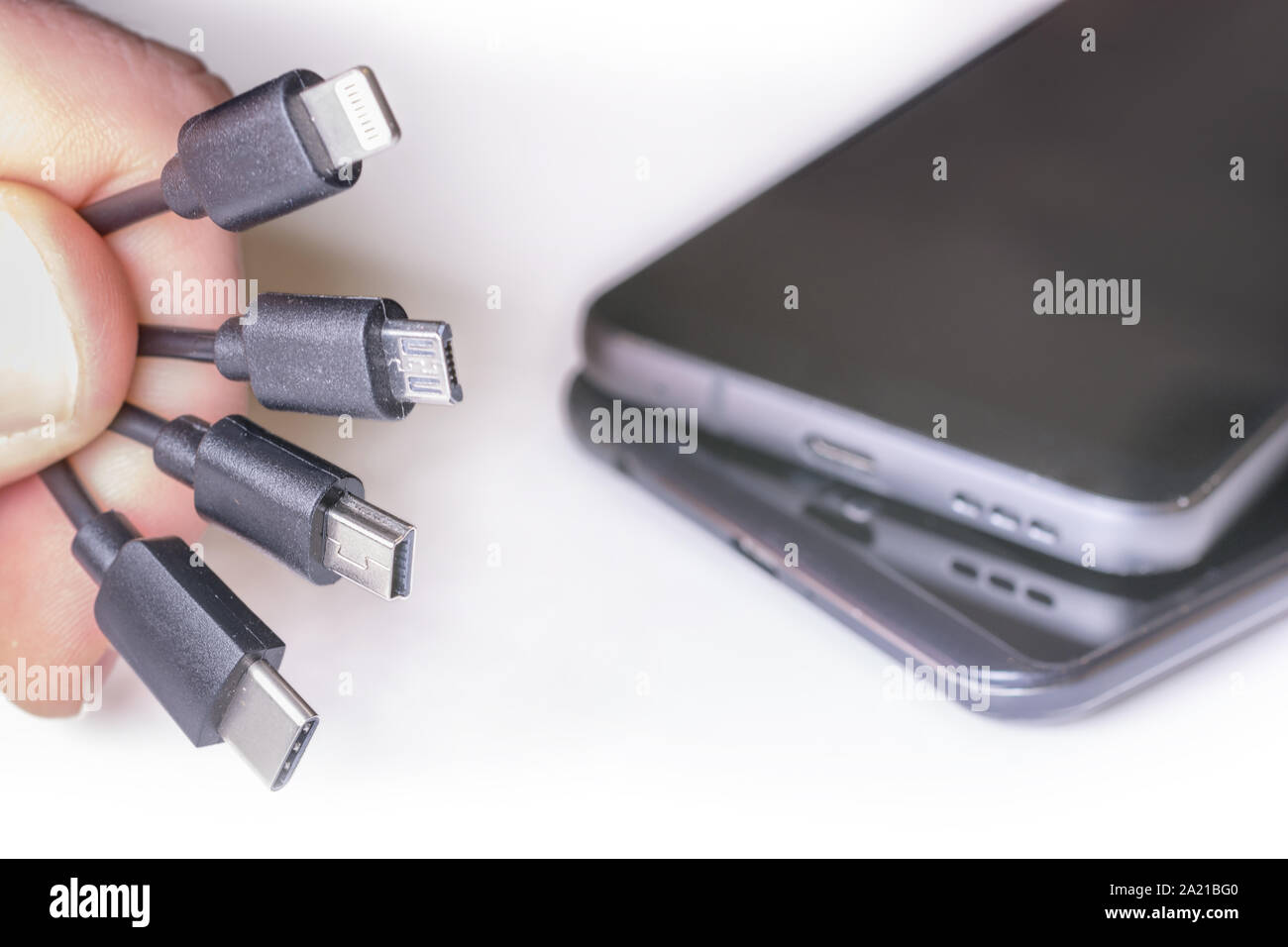 Various charging cables with mobile phones Stock Photo Alamy