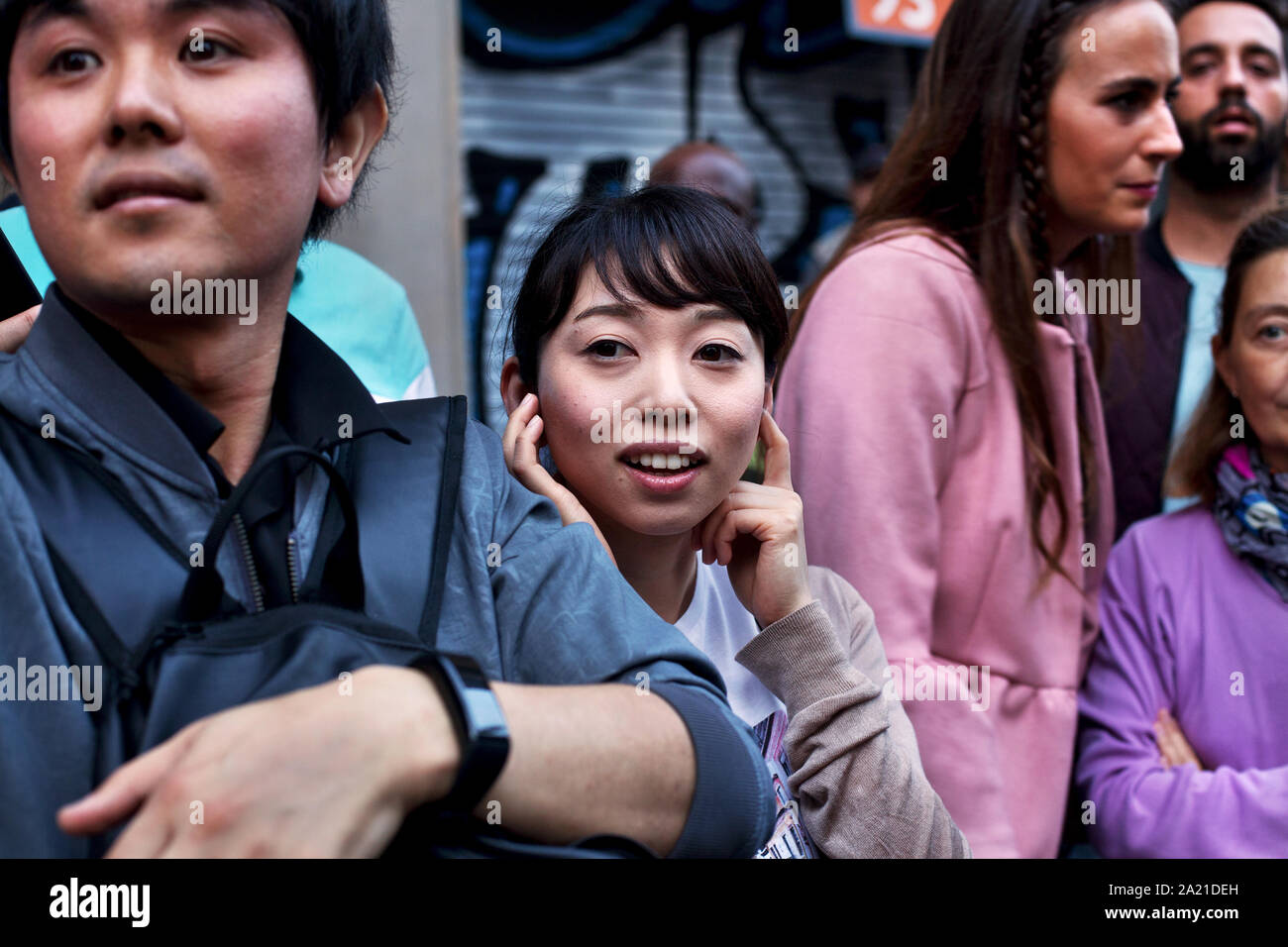 Young Asian woman protecting her ears from the sound of noisy fireworks. Stock Photo