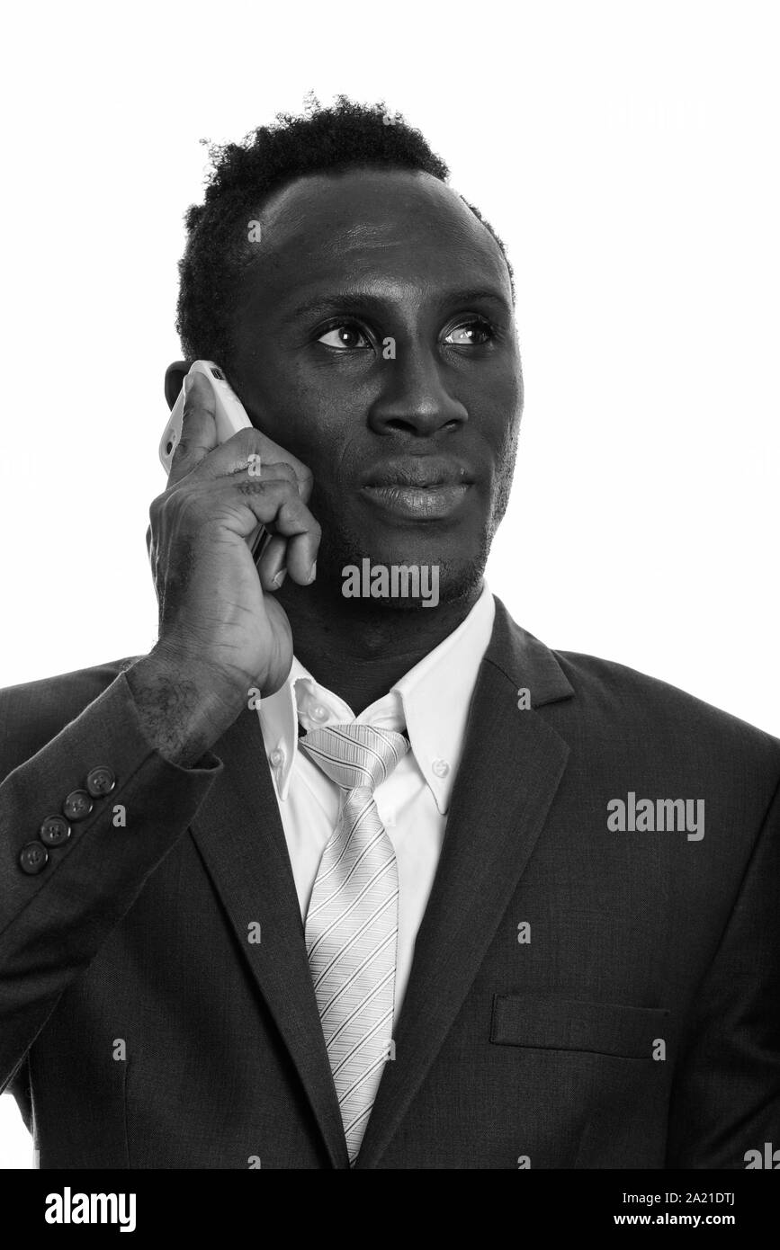 Face of young black African businessman talking on mobile phone while thinking Stock Photo