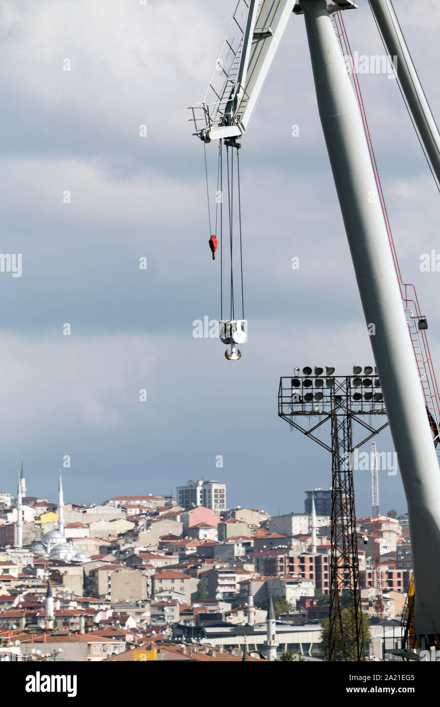 Hook and arm of a heavy crane with cityscape in the background. Large copy space. Stock Photo