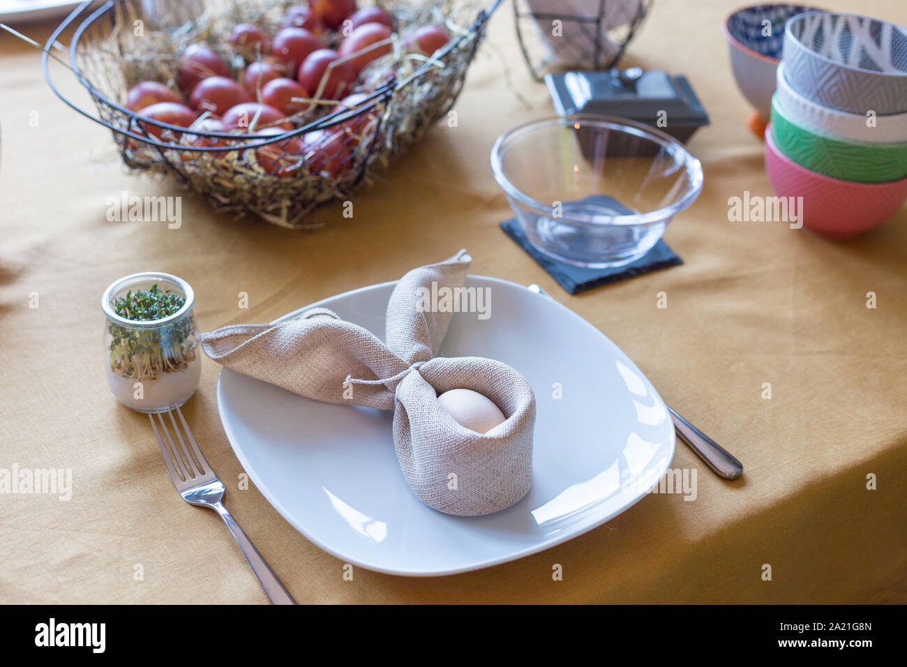 Real family table set for Easter breakfast in traditional Polish home. Basket filled with eggs colored with onion skins. Stock Photo