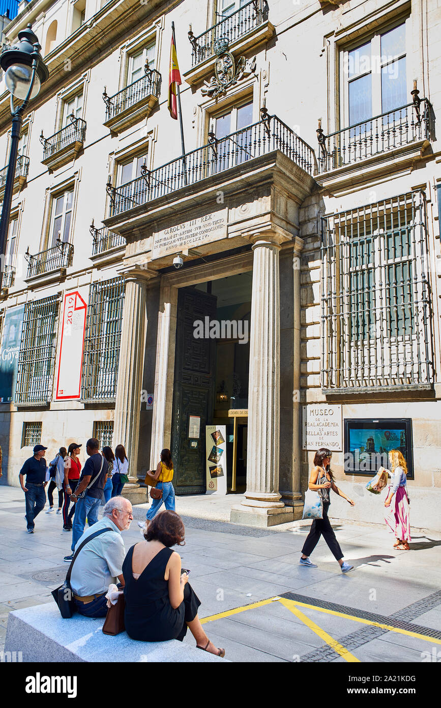 Tourists walking in front of principal facade of The Royal Academy of Fine Arts of San Fernando. View from Alcala street. Madrid, Spain. Stock Photo