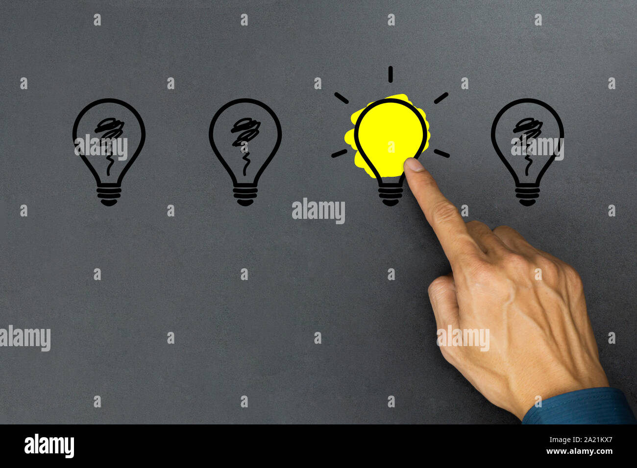 Creative ideas concept. Conceptual different thinking or leadership. A businessman hand choose a one shining light bulb and many light bulb goes out o Stock Photo