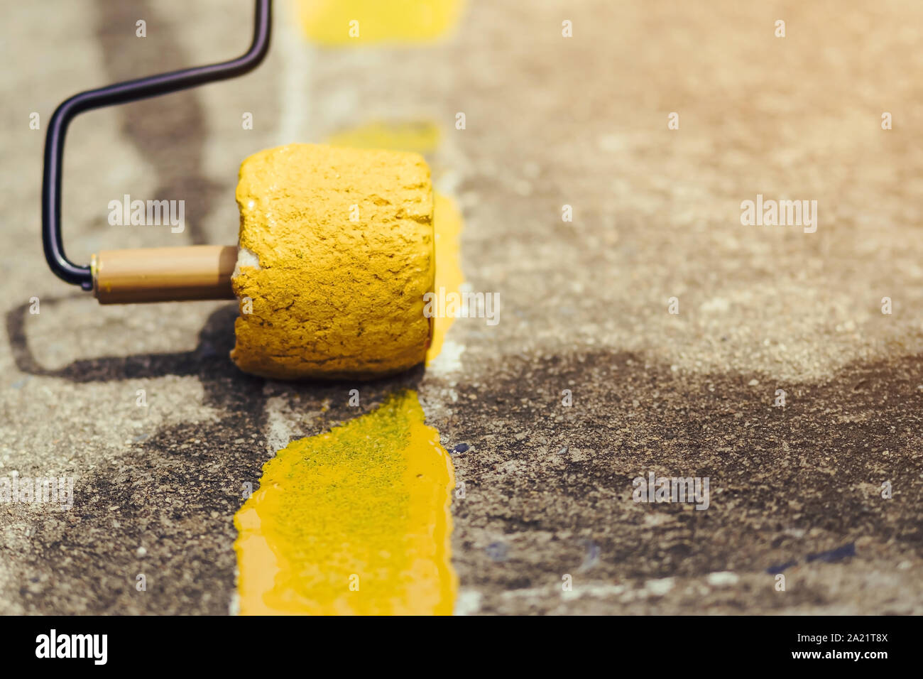 Male Students Use Small Paint Rollers To Paint Yellow Lines On The
