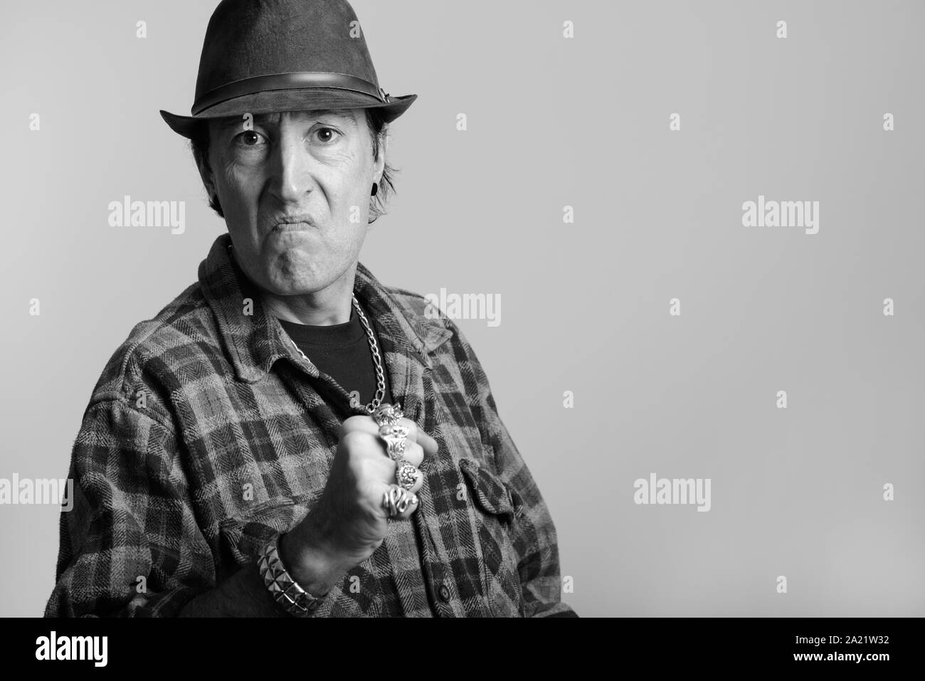 Studio shot of angry mature gangster man with fist raised Stock Photo