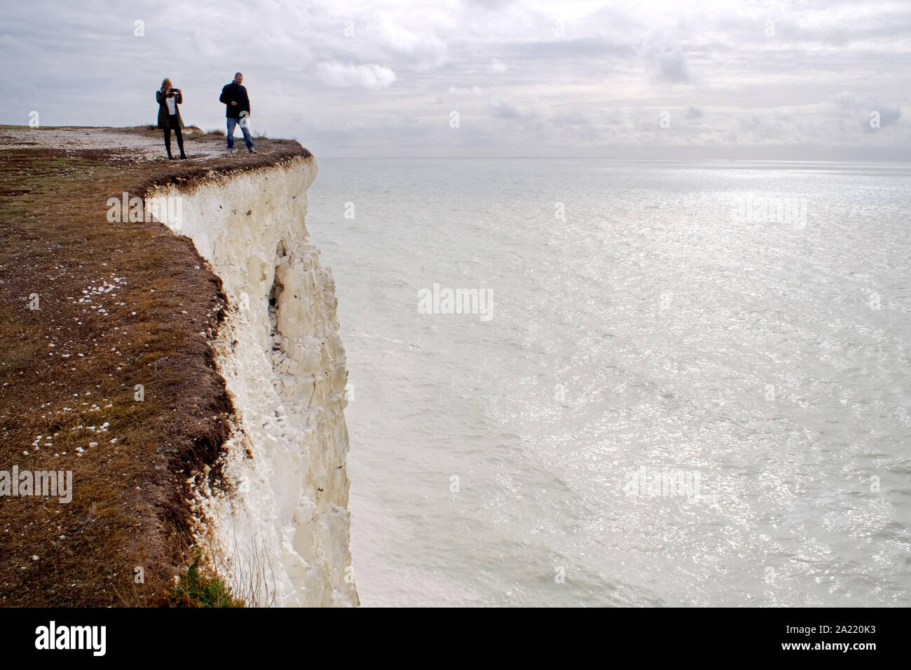 Birling Gap, East Sussex, UK. 30th Sep, 2019. Recent cliff falls along the coast near the iconic Seven Sisters chalk cliffs have turned the sea white. Steps to the beach have been closed due to the danger of further falls but despitre the risk, tourists are still getting too close to the edge of the 400 foot drop to get selfies. One man was seen jumping close to the edge. A newlywed couple was also seen having photos taken at the edge of the crumbling cliffs. Credit: Peter Cripps/Alamy Live News Stock Photo
