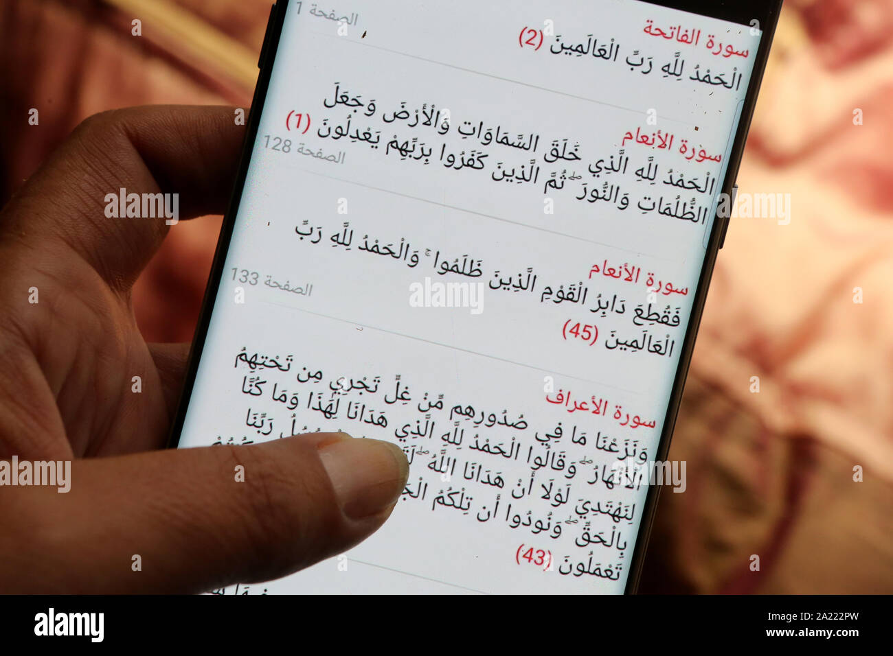 Jeune femme lisant le Coran sur son téléphone portable. Stock Photo