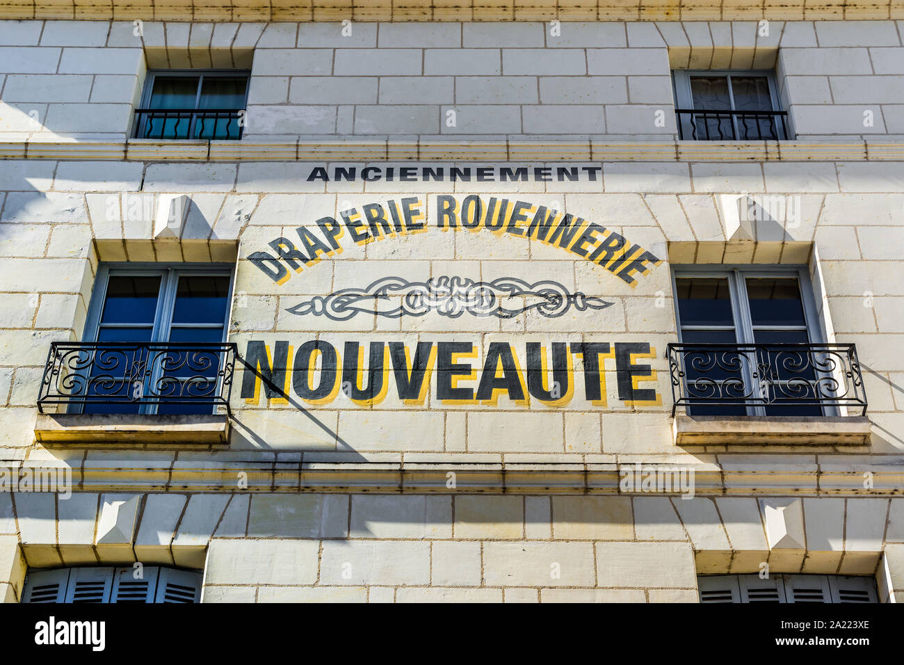 Repainted signwriting on wall of drapery shop - Loches, Indre-et-Loire, France. Stock Photo