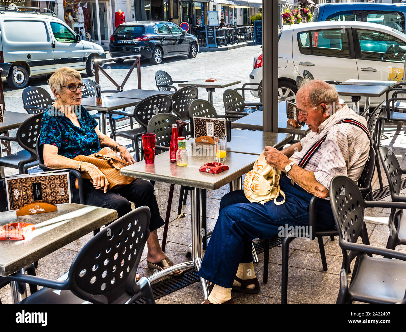 Elderly retired couple with refreshments at cafe table - Loches, Indre-et-Loire, France. Stock Photo