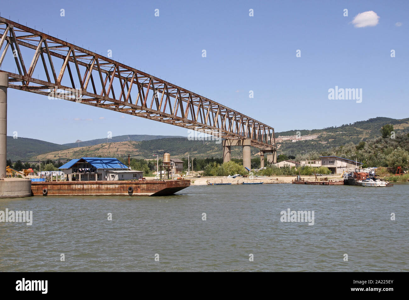 Unnamed bridge on the Danube River with construction site and blue house on the Romanian side on the border beween Romania and Serbia, Romania. Stock Photo