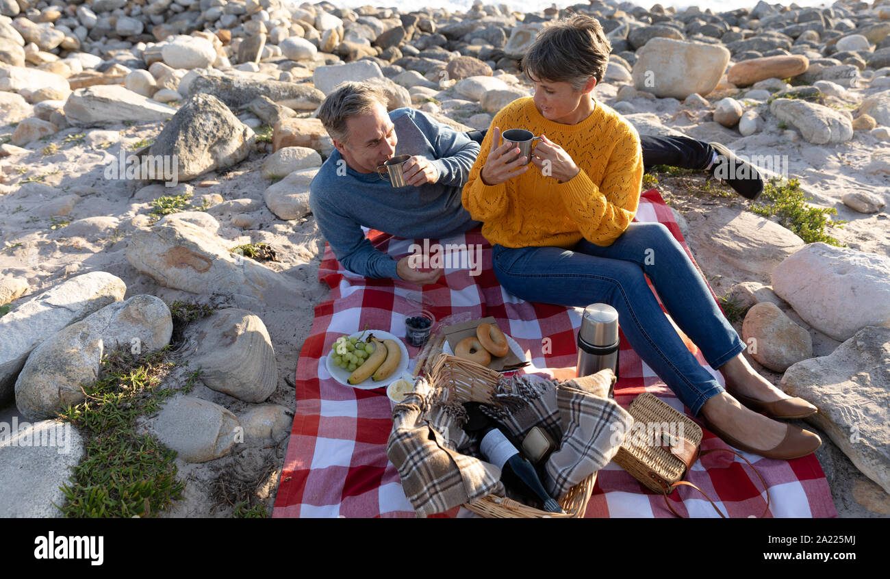 Couple having a picnic by the sea Stock Photo Alamy