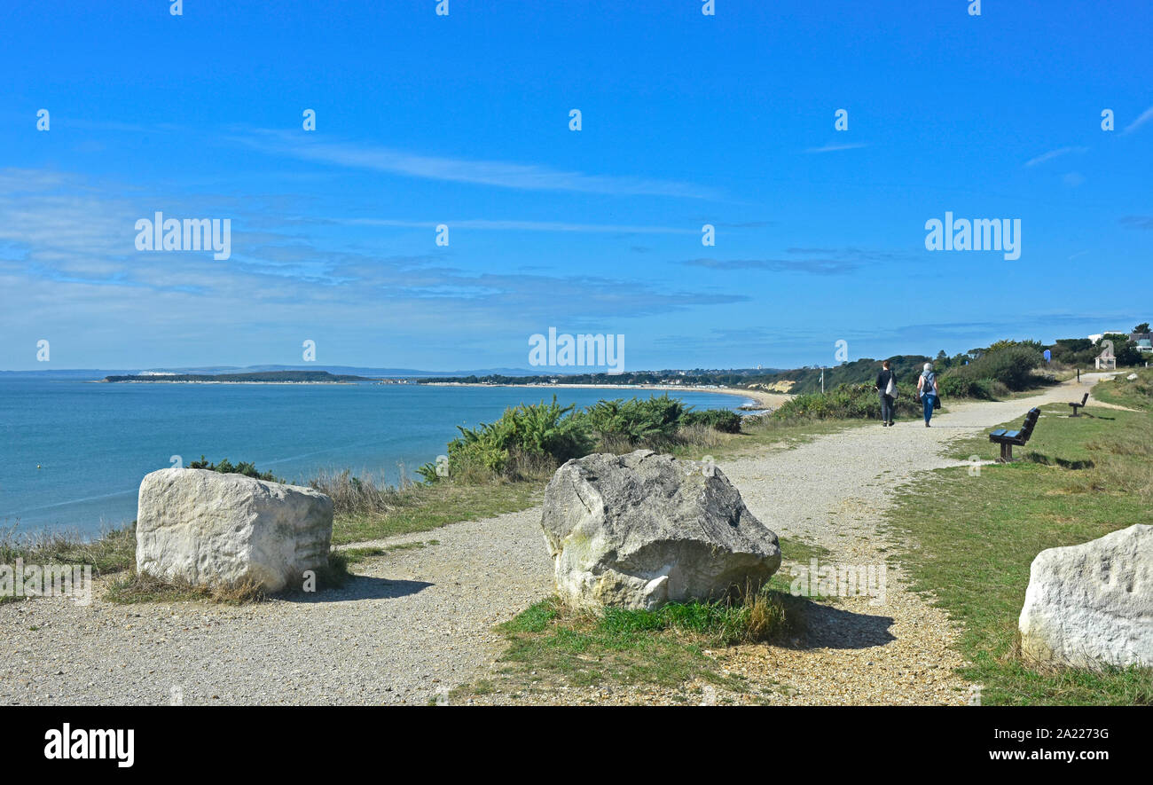 Highcliffe - Dorset - clifftop pathway - walkers - view over the bay - summertime - bright sunshine - blue sea and sky Stock Photo
