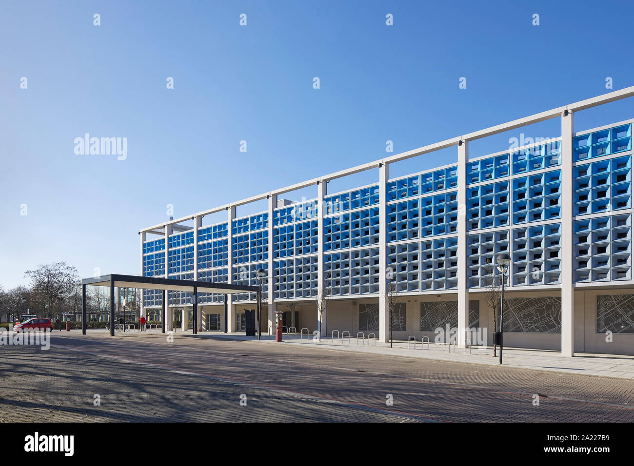 Perspective along exterior facade with stone panels and perforated metal screens. Centre MK, Milton Keynes, United Kingdom. Architect: Leslie Jones Ar Stock Photo